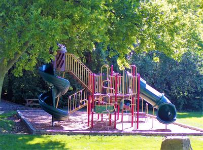 A play structure with a slide in a park